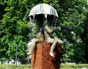 Sculptures of boys with an umbrella in the fountain